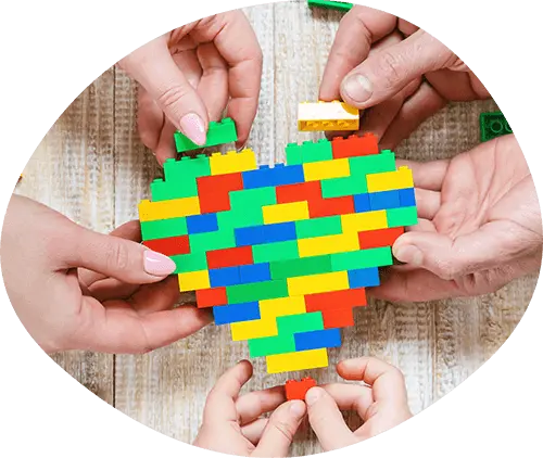 Multiple people making a heart out of LEGO's